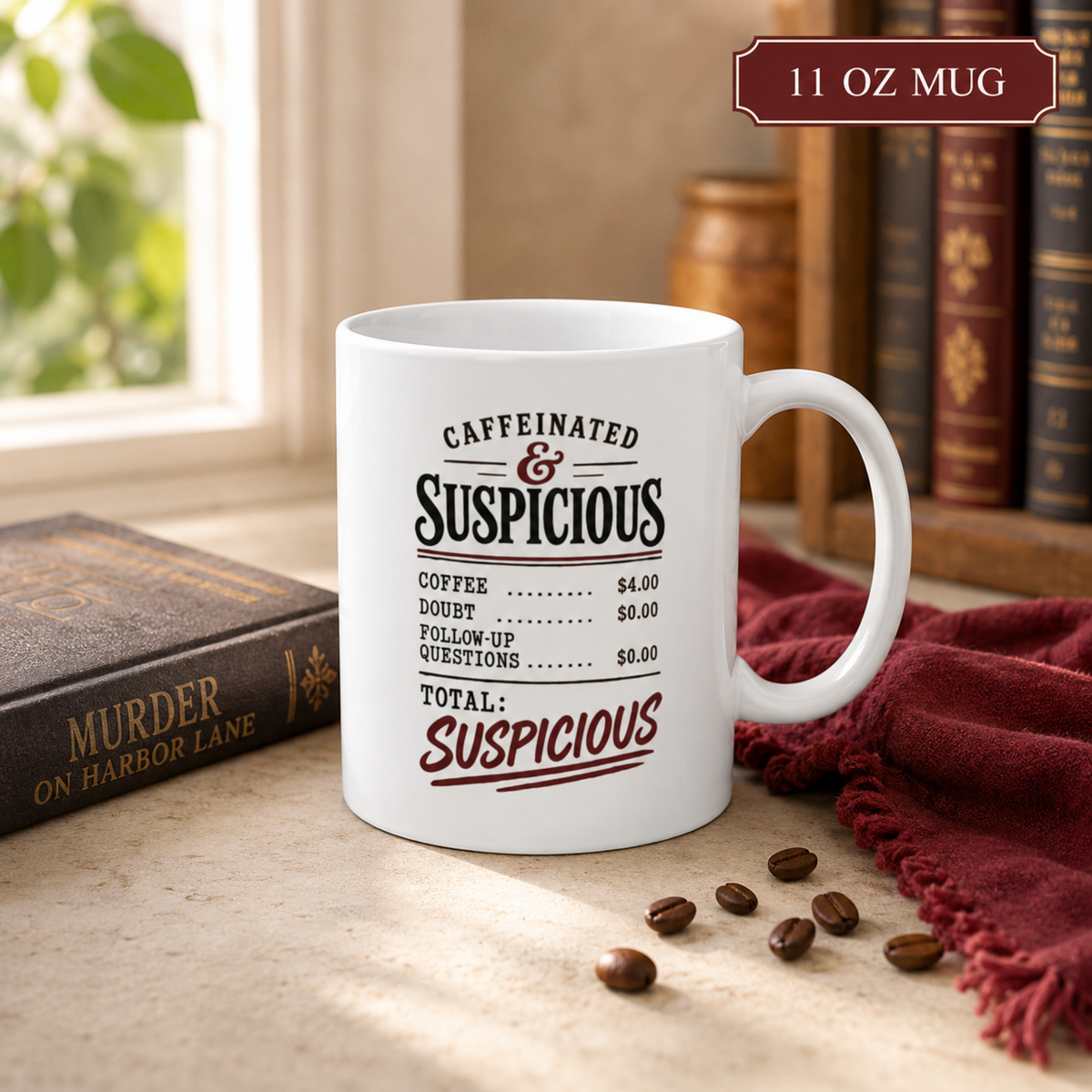 11 oz white “Caffeinated & Suspicious” receipt-style mug on a tabletop beside a mystery novel, burgundy cloth, and coffee beans.