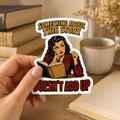 Hand holding a white-bordered sticker reading “Something About This Story Doesn’t Add Up,” featuring a retro reader in a red jacket studying an open book.
