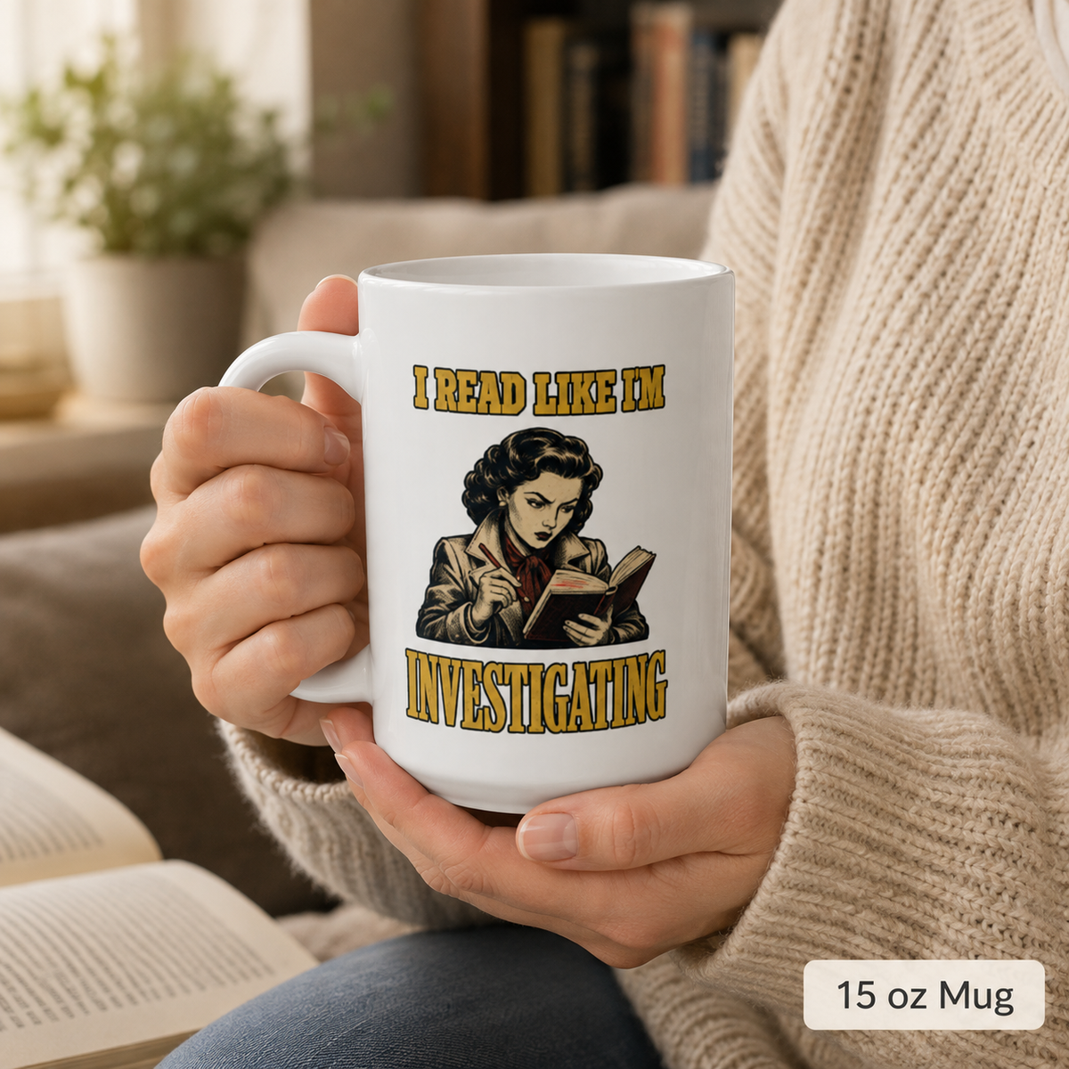 Person holding the white 15 oz I Read Like I’m Investigating mug with an open book visible below.