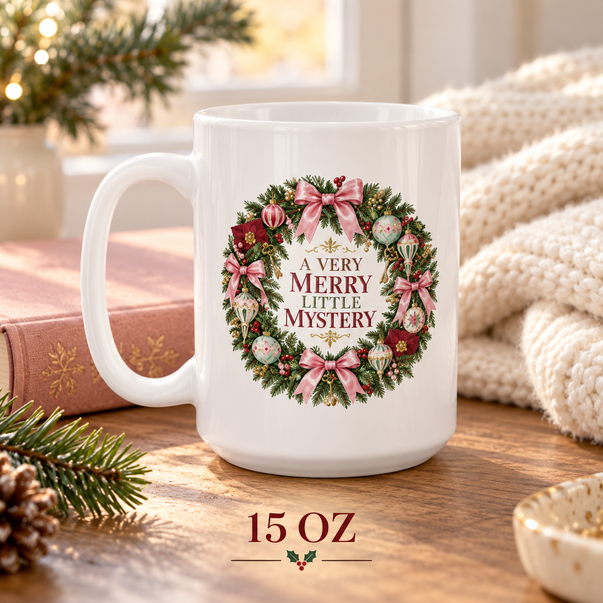 15-ounce “A Very Merry Little Mystery” mug on a wooden table beside a pink holiday book, evergreen branch, cream knit blanket and warm window light.