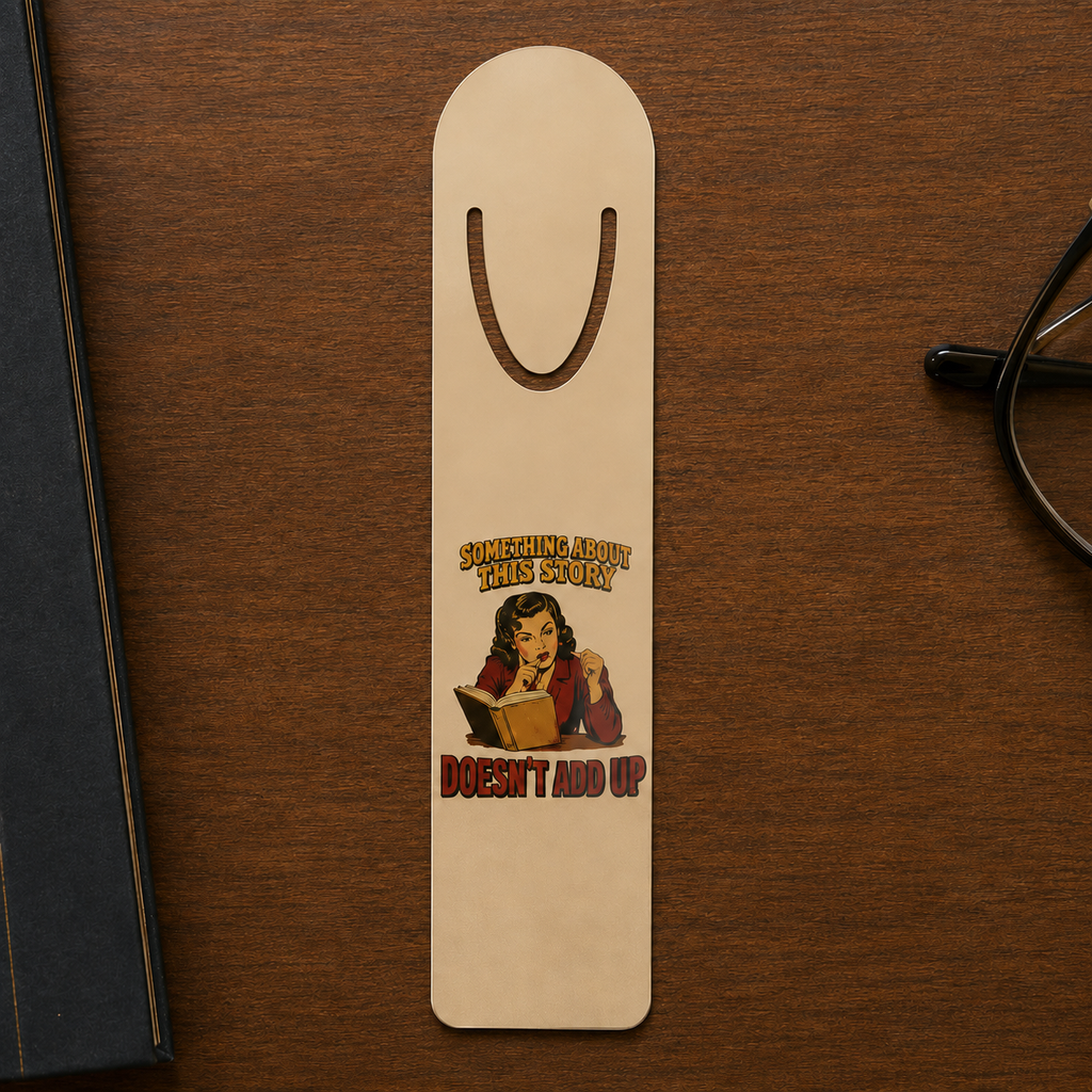 Gold-tone aluminum bookmark on a dark wood desk with artwork of a reader studying an open book and the words “Something About This Story Doesn’t Add Up.”