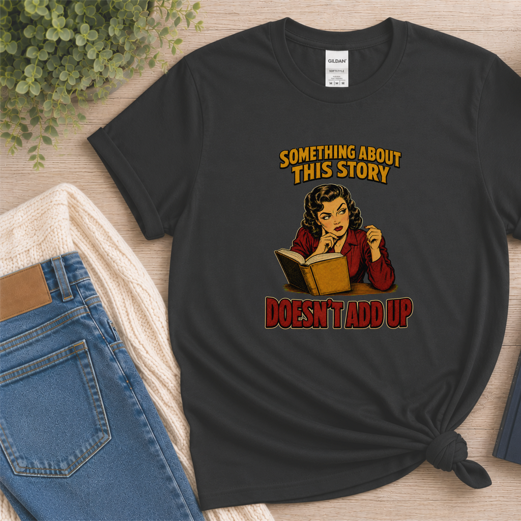Black T-shirt laid flat with an illustrated reader holding an open book and the words “Something About This Story Doesn’t Add Up.”