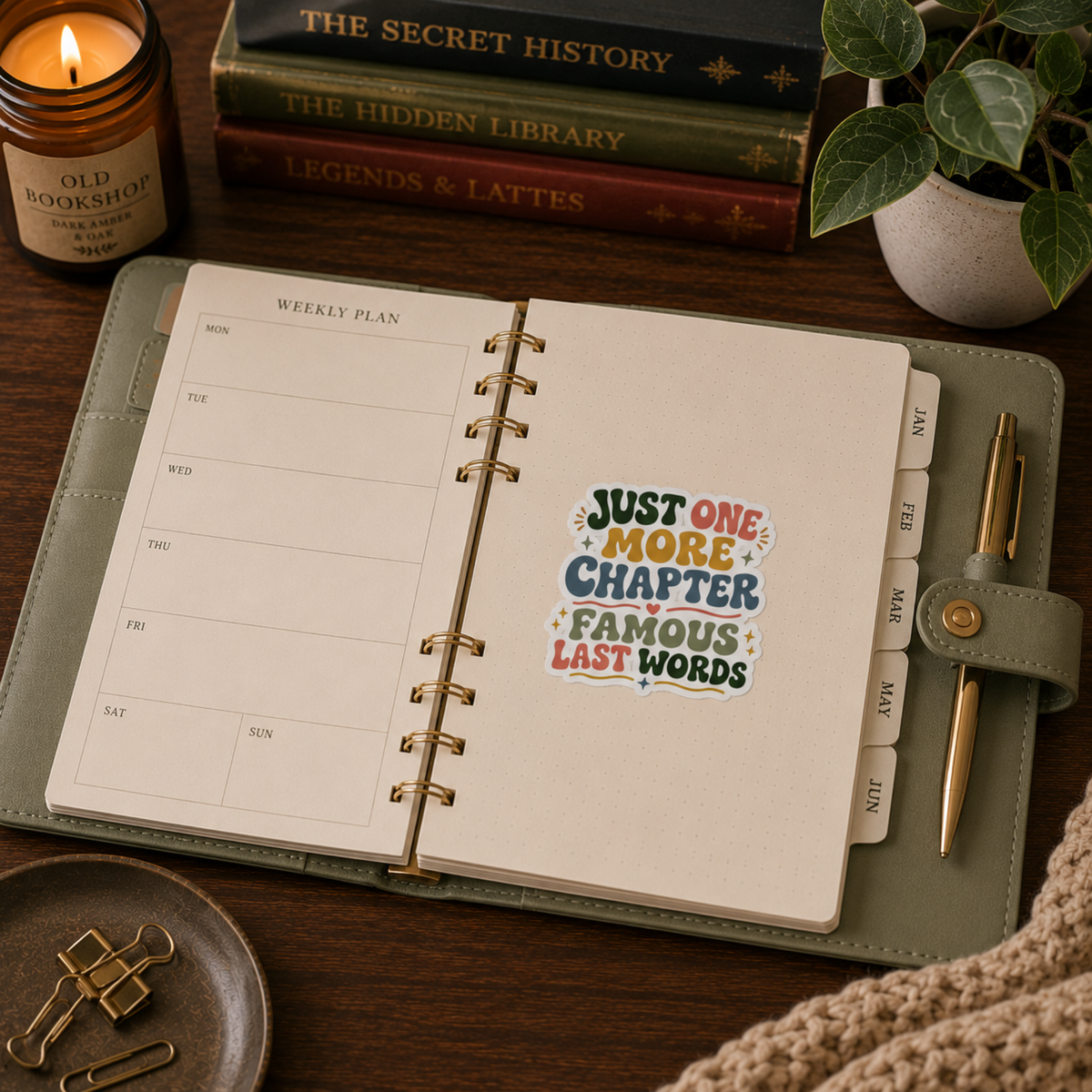“Just One More Chapter. Famous Last Words” sticker with green, coral, gold, and blue retro lettering with hearts and sparkles, shown on a open ring-bound planner.