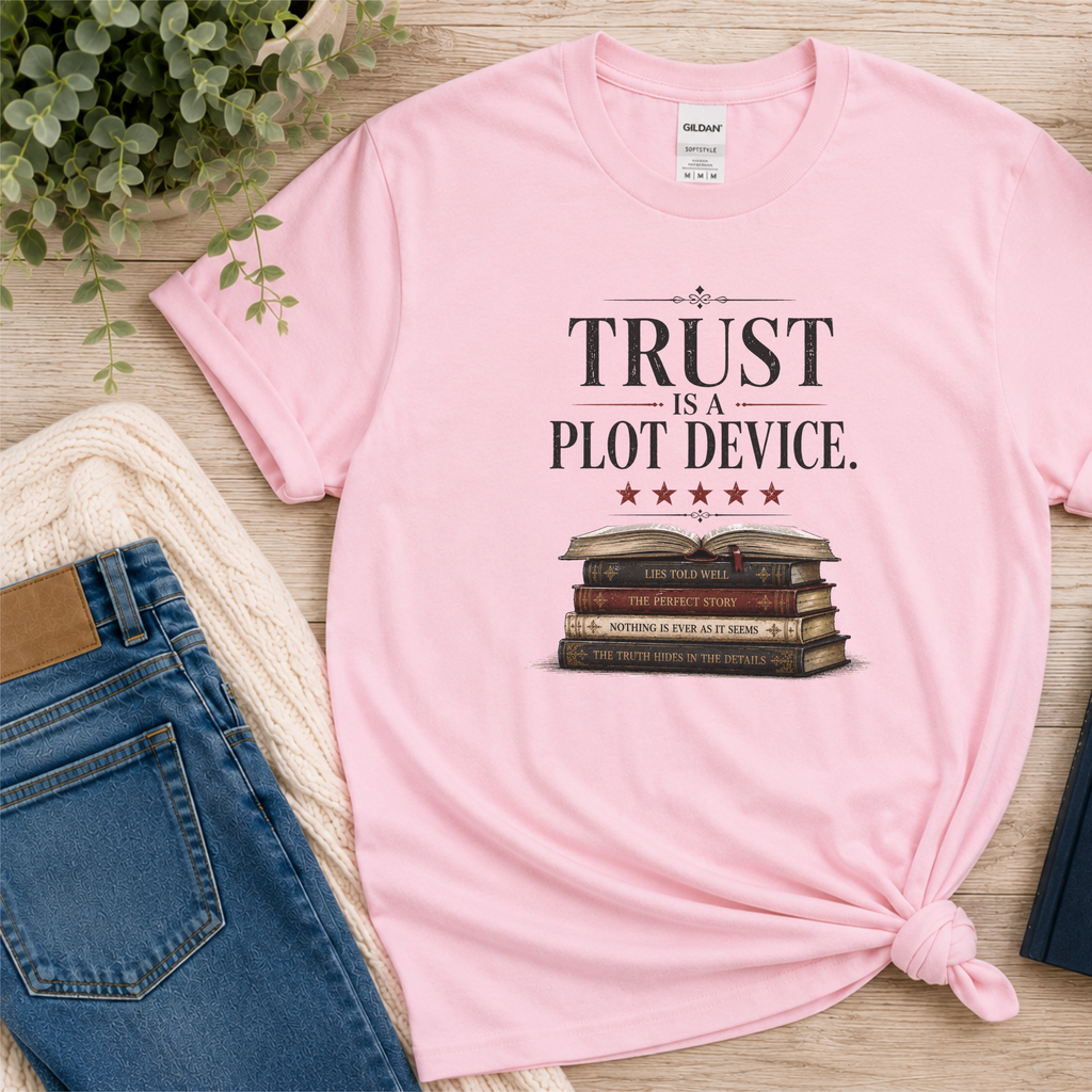 Light pink T-shirt laid flat with stars above a stack of books and the words “Trust Is a Plot Device.”