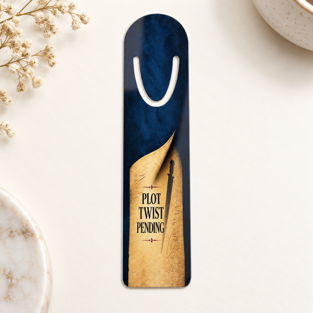 Navy aluminum page-holder bookmark featuring a curled parchment page, dagger silhouette, and the words “Plot Twist Pending,” on a cream surface.