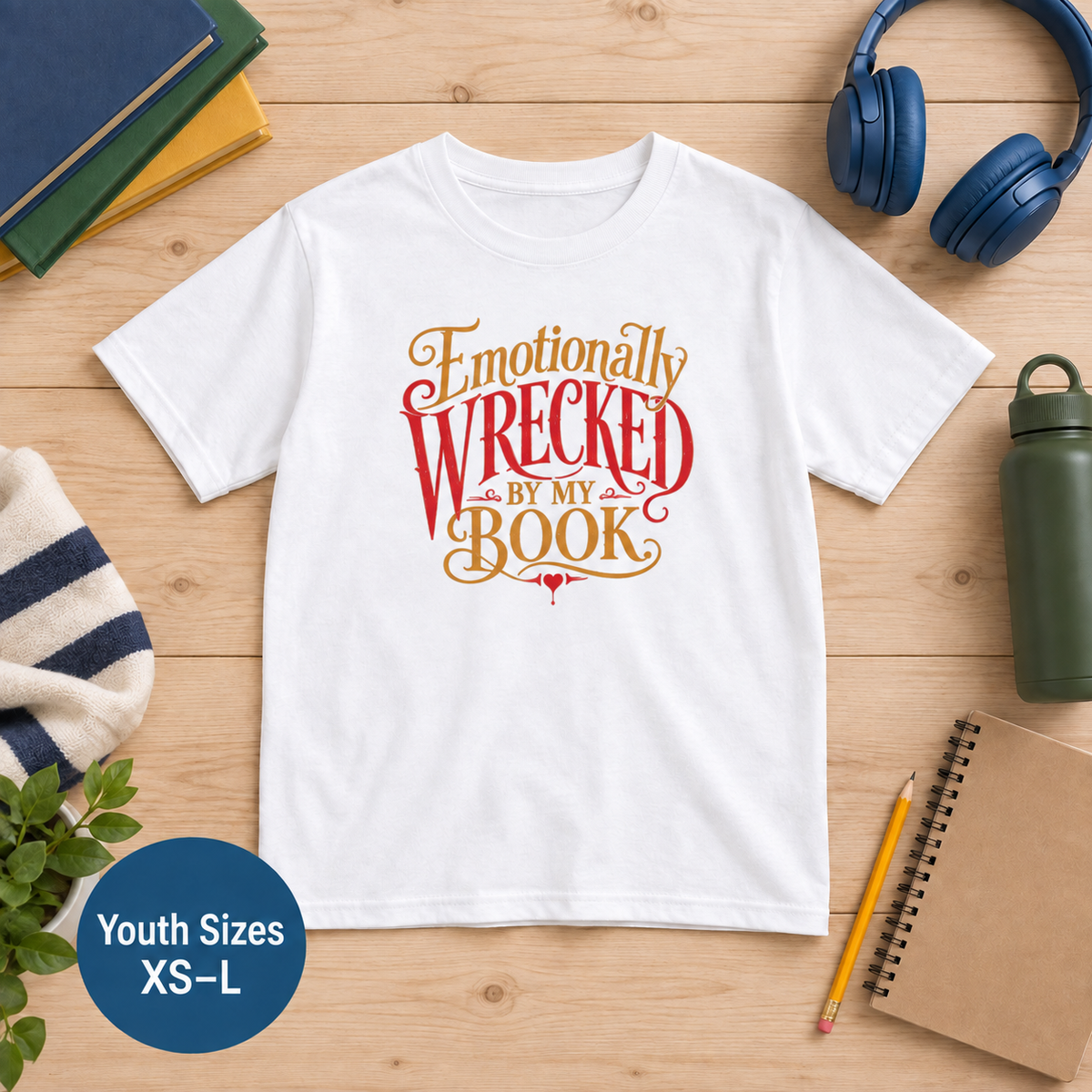 Youth White T-shirt laid flat with ornate red and gold lettering and the words “Emotionally Wrecked by My Book.” Image label: youth sizes XS–L.