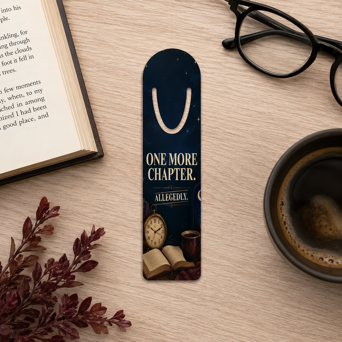 Navy “One More Chapter. Allegedly.” bookmark with antique clock, open book, and warm drink artwork on a wooden table beside an open book, glasses, and coffee.