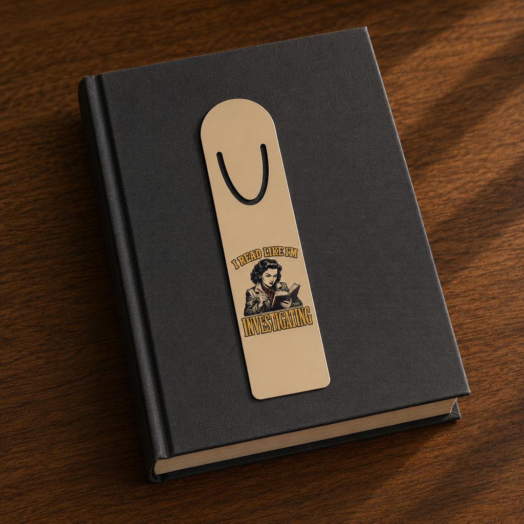 I Read Like I’m Investigating aluminum bookmark displayed on a closed black hardcover book.