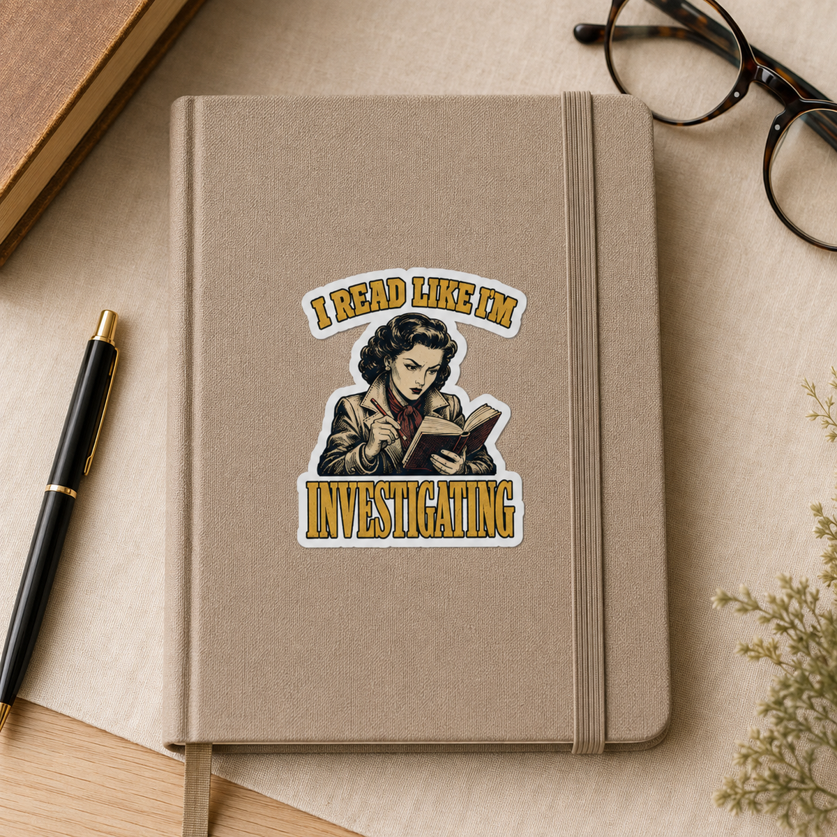 “I Read Like I’m Investigating” sticker with a retro reader taking notes while reading, framed by gold lettering, shown on a beige notebook.
