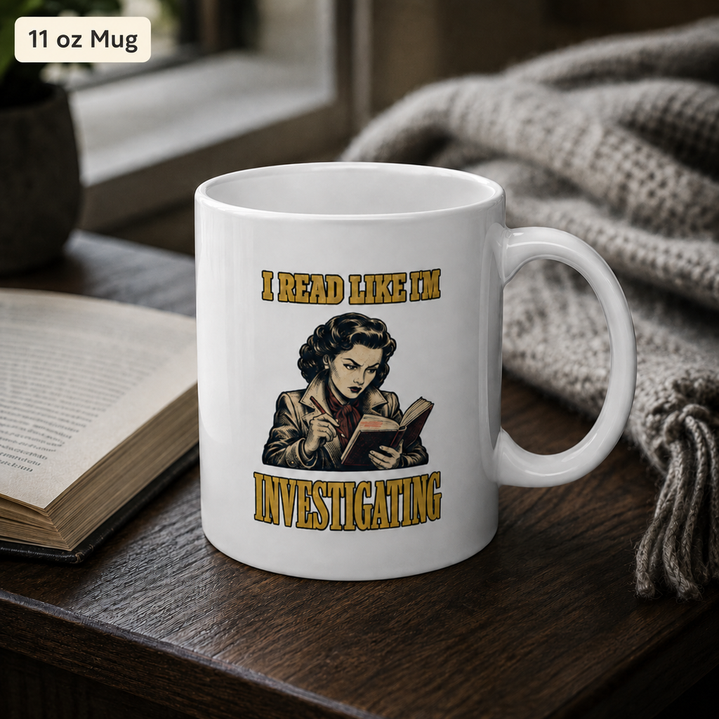 White 11 oz I Read Like I’m Investigating mug on a dark wood side table beside an open book and knit blanket.